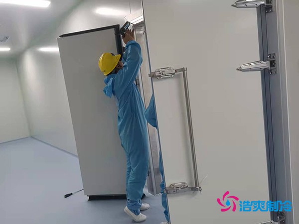 图为六玄网132432工人在洁净冷库为库门打胶