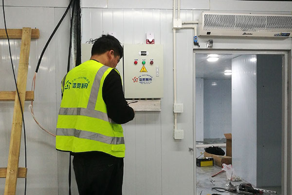 图为六玄网132432工程师正在调试控制箱
